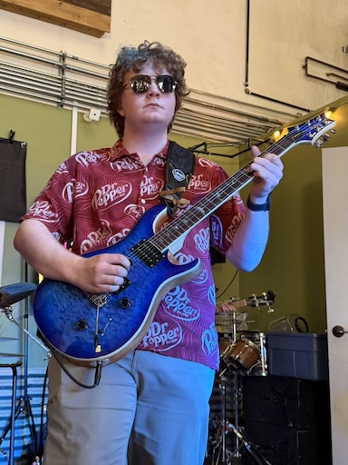 Cade holding a blue guitar
